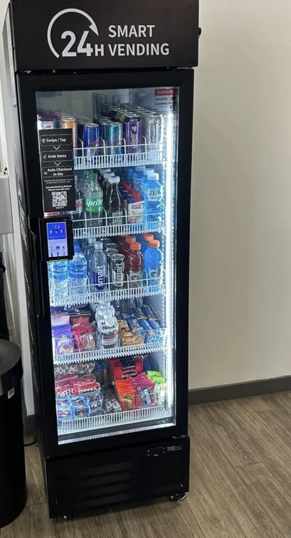 Fully stocked smart vending cooler against a wall